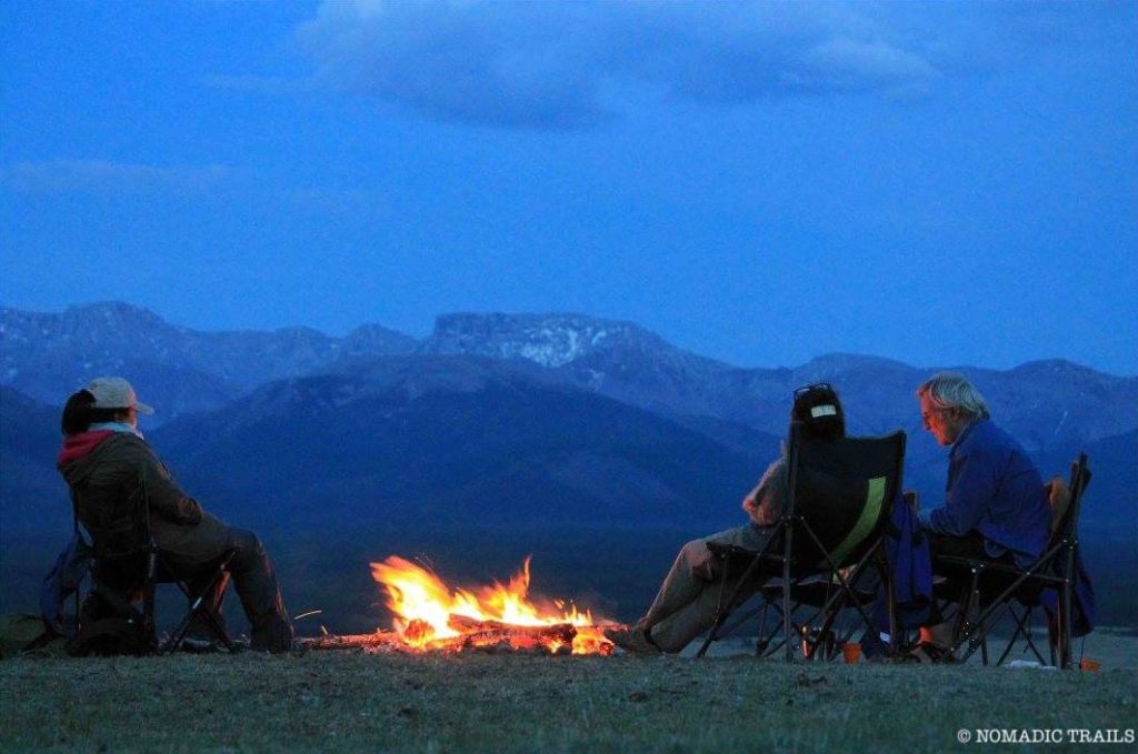 tented camping relaxing near bonfire at night