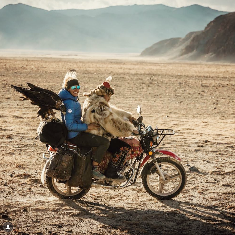 Eagle hunter and client fun ride with motorbike